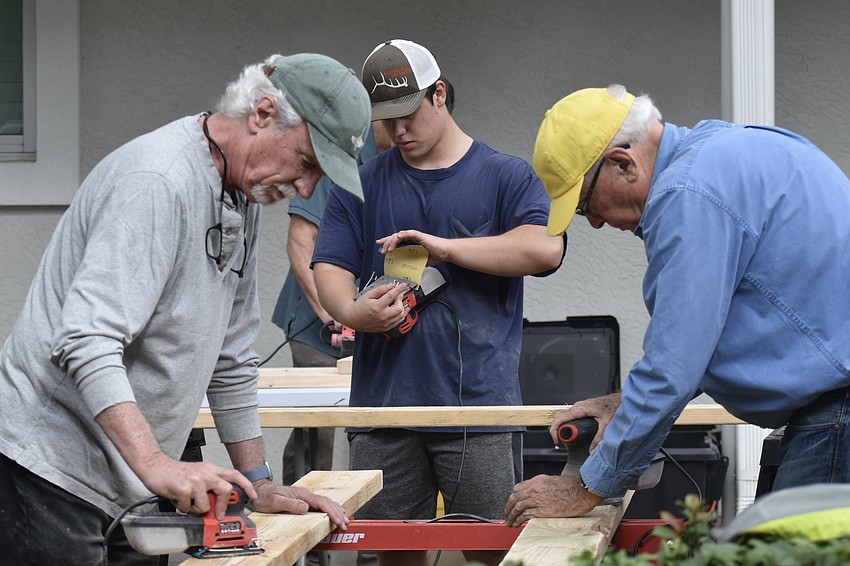 Patrick McGeehan, Gavin Kubisiak, 17 and Marty Faust work on sanding the boards.