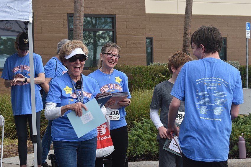 Suncoast Stars Community founder Mary Lou Fenton and Board Member Julie Audet congratulate Gabe Carlin on placing second in his age group.
