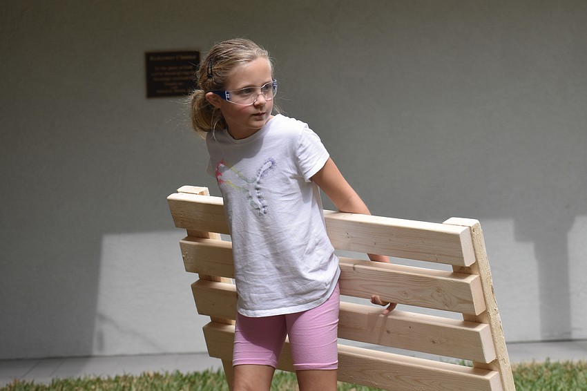 Allie Selbog, 8, carries a finished piece to add it to the ones to be distributed.