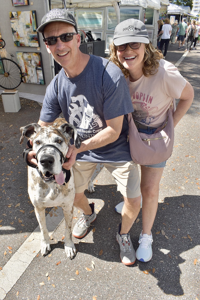Pebbles, a Great Dane, and his owners Jeff and Jill Tabak, take a walk through the festival.