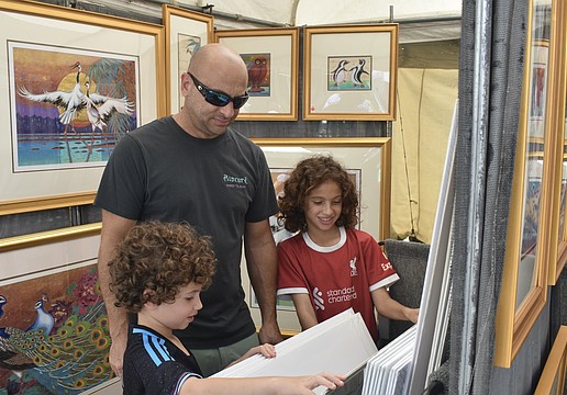 Gideon Demetrious, 6, Hani Demetrious and Jude Demetrious, 10, look through a series of prints.