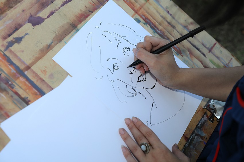 Student artists leave their mark as they draw portraits of guests.