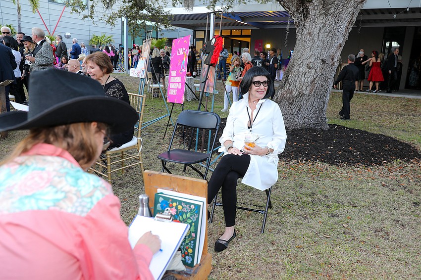 Mary Ann Jordan sits and sips while her portrait is being made.