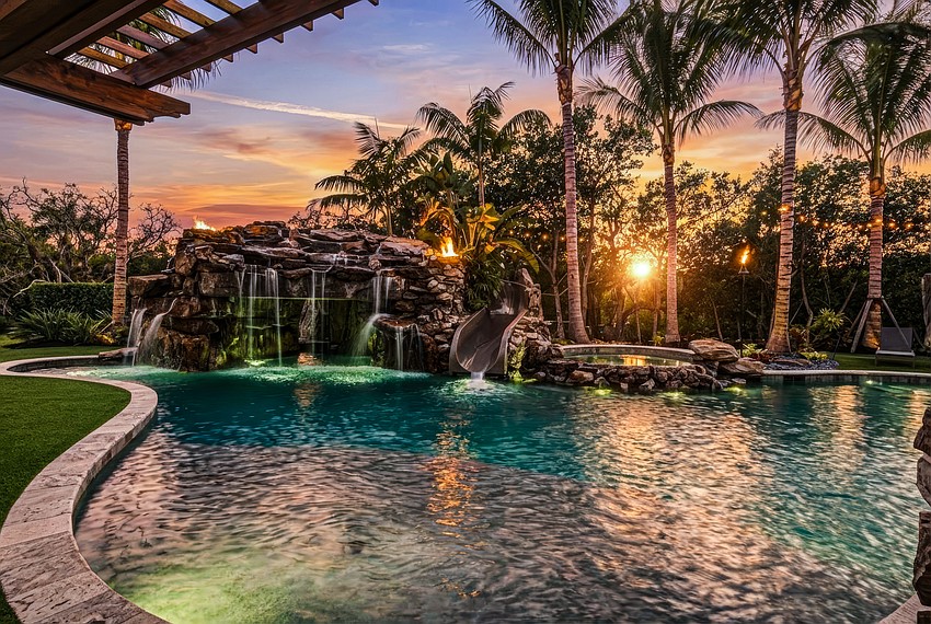 Natural stone anchors the saltwater pool, which features a bubbling spa, waterfalls, fire bowls and waterslide.