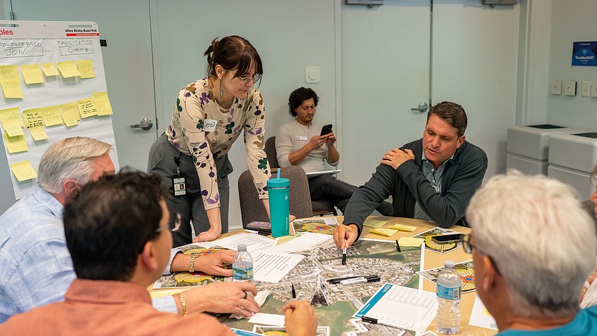 St. Armands Residents Association President Chris Goglia points to a map in the middle of the table as participants discussed what their vision for St. Armands Circle in 20 years was. At the visioning workshop, participants were broken into 20 tables to brainstorm before presenting their vision one at a time.