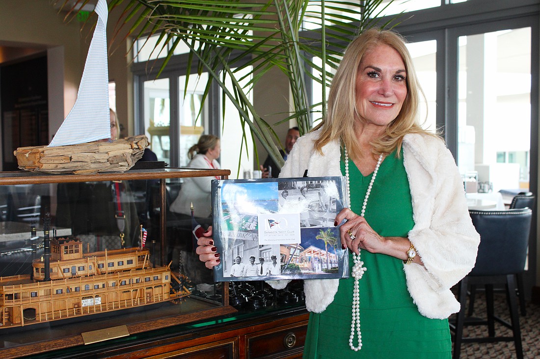 Lynne Short, chair of the Centennial Committee at the Sarasota Yacht Club, shares how the club dove into its own history to produce a book and a full year of events based on the past 100 years. She stands beside a model of the Zalophus, a 125-foot yacht John Ringling purchased in 1922.