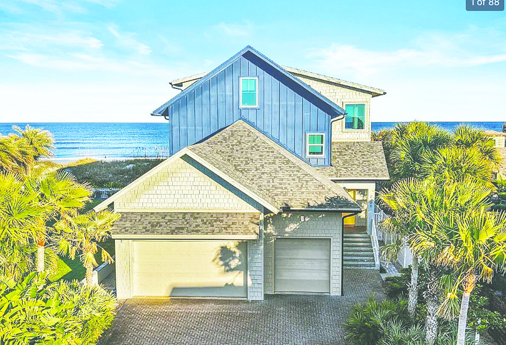 Oceanfront three-story home features four bedrooms, three bathrooms, porches, patio and three-car garage.
