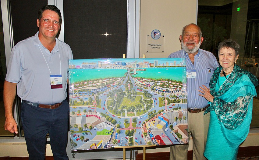 St. Armands Key Residents Association president Chris Goglia surprises Mike Adkinson and Mari Lynn Cheatham with the 2026 Community Impact Award at the association's annual dinner March 3 at the Sarasota Yacht Club. In recognition of their work, they received a piece done by Robert the Artist.