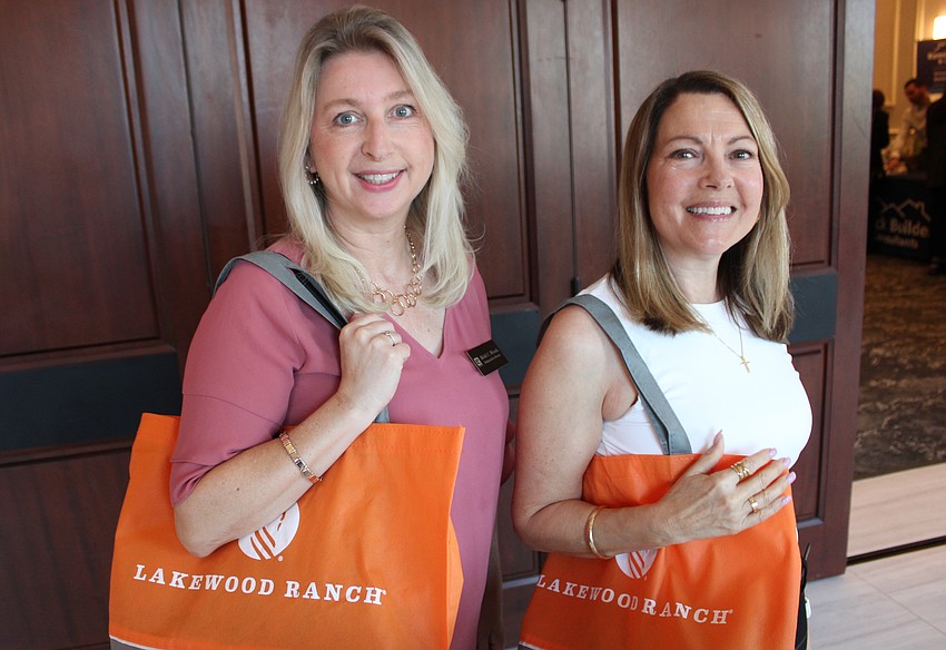 Heidi Woods, an independent broker, and Stacey Siciliano of Suncoast Realty Solutions, get ready to fill their bags with information during the 2026 Manatee Realtor Preview March 5 at the Grove.