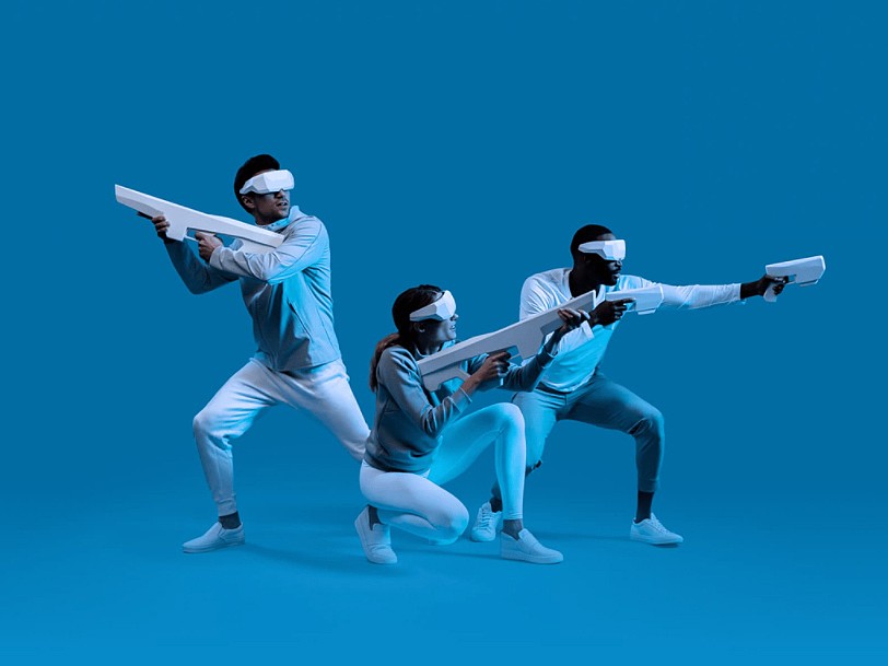 Three players using Sandbox VR headsets and accessories.