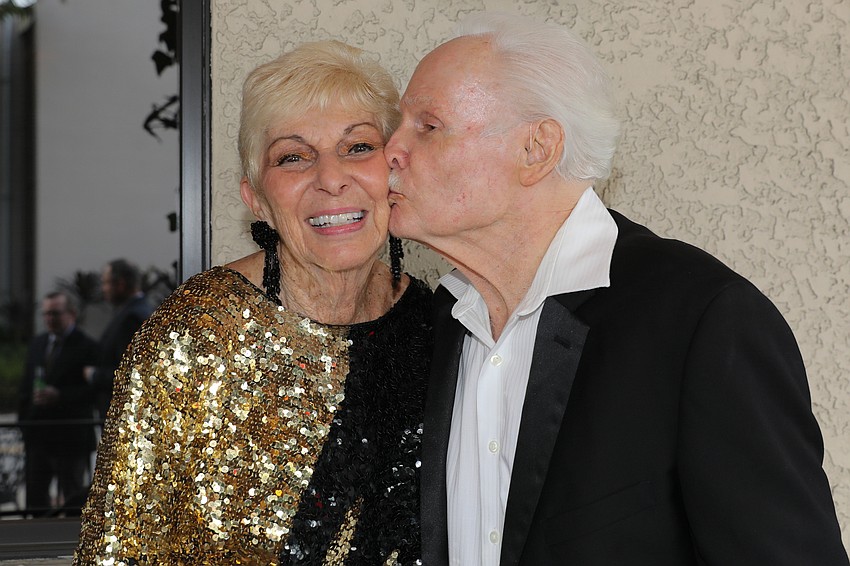 Event Chair Anita Devine gets a kiss from her husband, Kelly, for a job well done.
