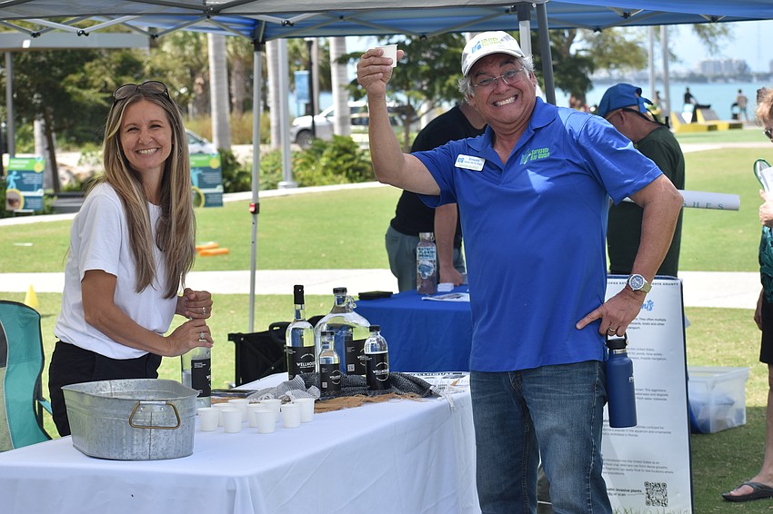 Rebecca Dawson of WellHouse lets Ernesto Lasso de la Vega of Sarasota Bay Watch enjoy her company's water.