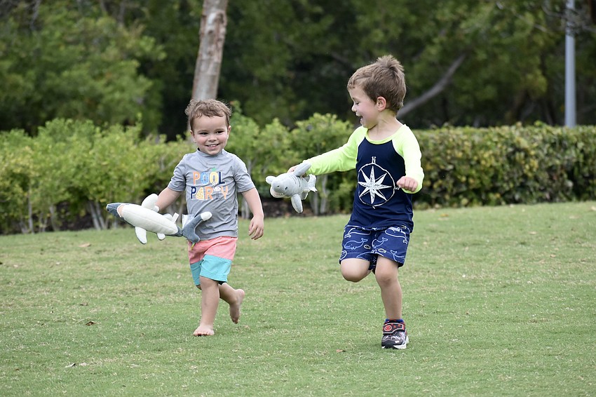 Harrison Hincker, 2, and Henry Hincker, 4, make a run across the field with some shark friends.