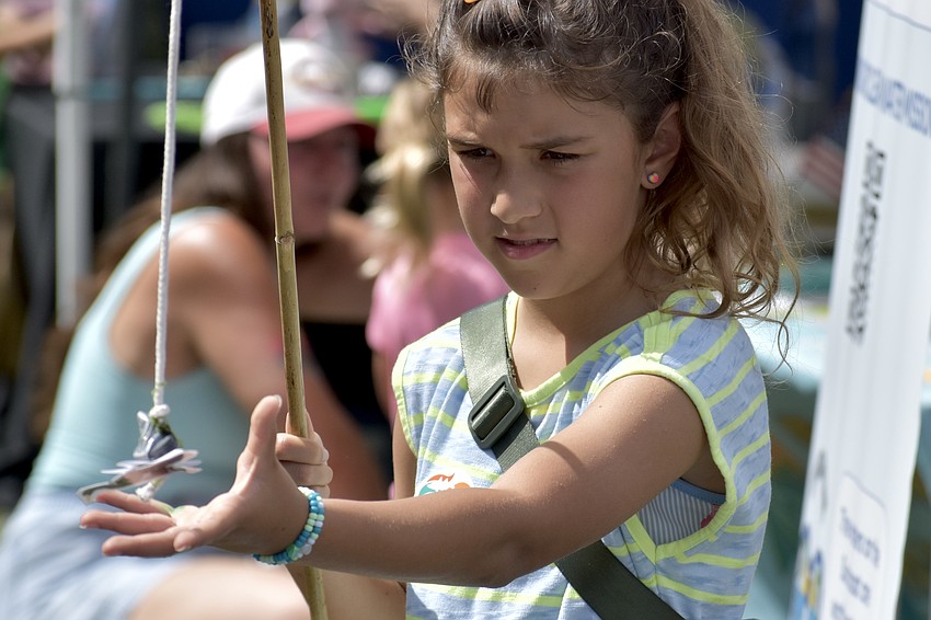 Emmy Lou, 10, removes a piece of litter in a display at Suncoast Waterkeeper.