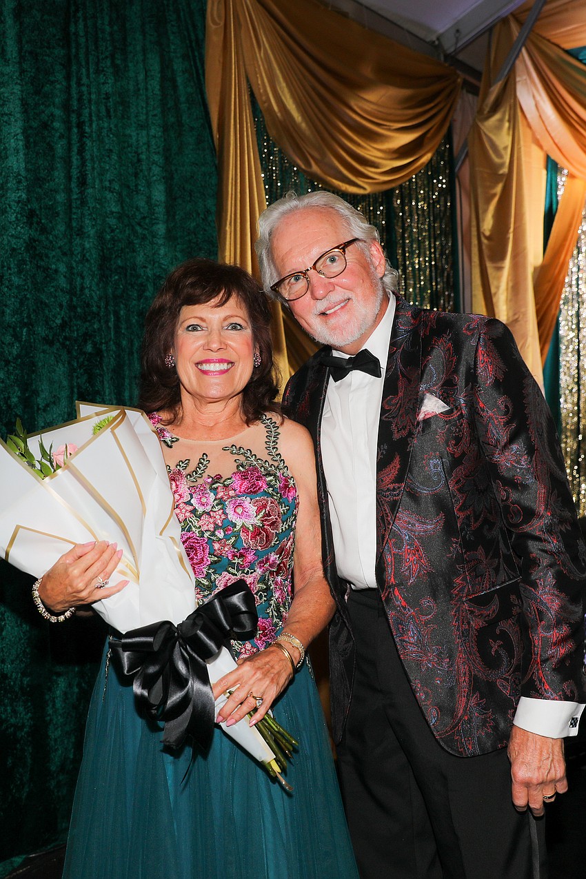 Event co-chairs Melba Ramirez and Jim Matras are presented with a bouquet of flowers.