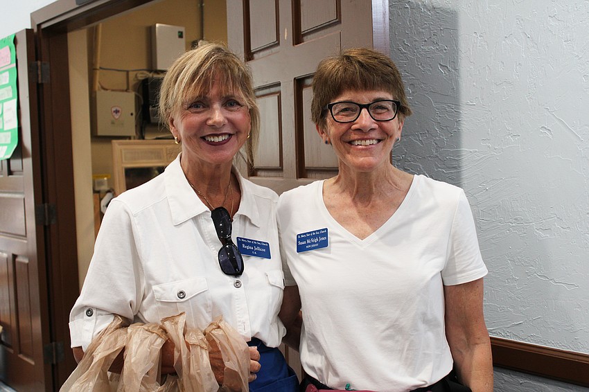 Volunteers Regina Jellicoe and Susan McVeigh Jones keep things moving in the clothing section of the Royal Rummage Sale.