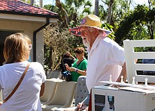 Al Van Iten helps out shopper Jenny Phillips with her purchase of a teak shower set at the Royal Rummage Sale. Van Iten said he appreciates helping out the charitable effort while getting to meet interesting people.