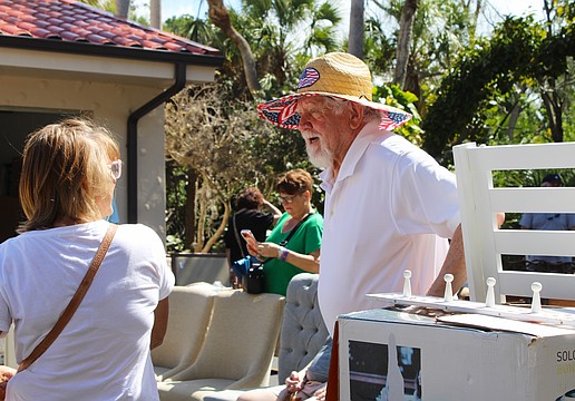 Al Van Iten helps out shopper Jenny Phillips with her purchase of a teak shower set at the Royal Rummage Sale. Van Iten said he appreciates helping out the charitable effort while getting to meet interesting people.