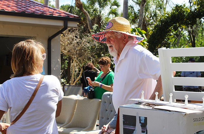 Al Van Iten helps out shopper Jenny Phillips with her purchase of a teak shower set at the Royal Rummage Sale. Van Iten said he appreciates helping out the charitable effort while getting to meet interesting people.