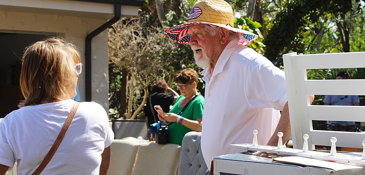 Al Van Iten helps out shopper Jenny Phillips with her purchase of a teak shower set at the Royal Rummage Sale. Van Iten said he appreciates helping out the charitable effort while getting to meet interesting people.