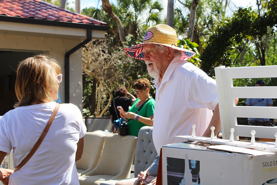 Al Van Iten helps out shopper Jenny Phillips with her purchase of a teak shower set at the Royal Rummage Sale. Van Iten said he appreciates helping out the charitable effort while getting to meet interesting people.