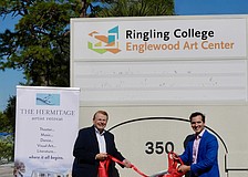 Larry Thompson and Andy Sandberg shake hands on the site of the Englewood Art Center at 350 McCall Road.