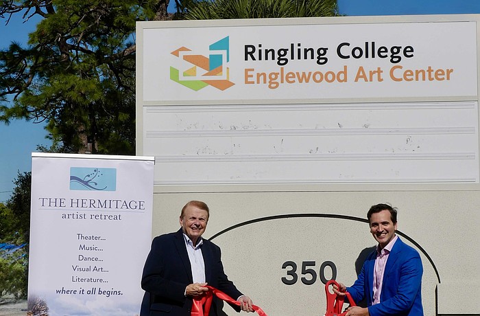 Larry Thompson and Andy Sandberg shake hands on the site of the Englewood Art Center at 350 McCall Road.