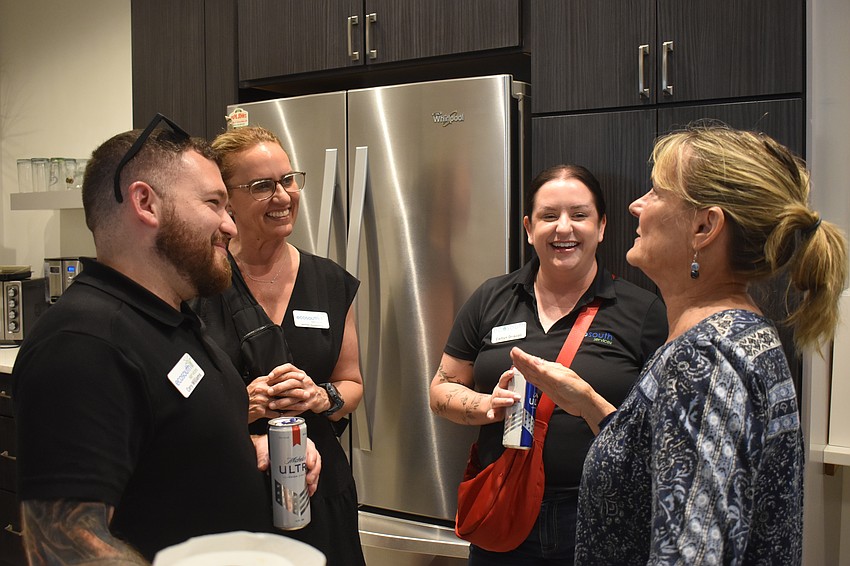 Cory Williams, Jennifer Houghtaling and Caitlyn Driscoll with EcoSouth Services socialize with Donna Leach, a purchasing agent with Lee Wetherington Homes, at the Chili Cook Off March 12.