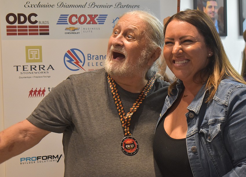 Bradenton's Carl Chitjian, the second place finisher of the Chili Cook Off, embraces his victory alongside Jessica Seper, the deputy executive officer and membership director of Suncoast Builders Association.