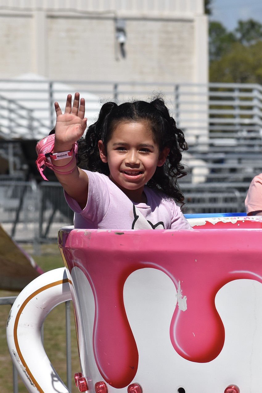 Anneis Costilla, 7, waves from a spinning teacup.