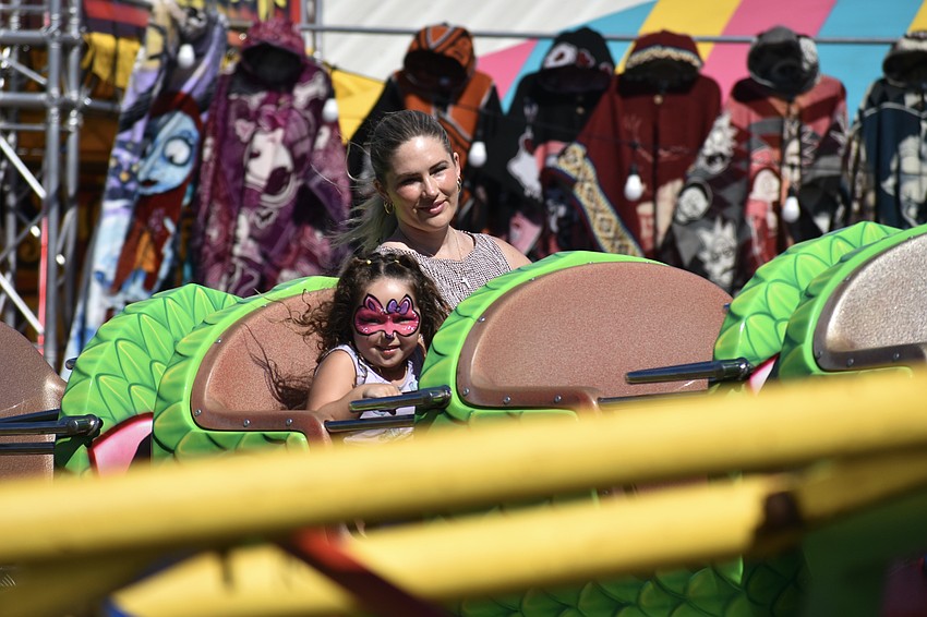 Isabella Pereyra, 5, and her mother Leslie Pereyra, enjoy a roller coaster.