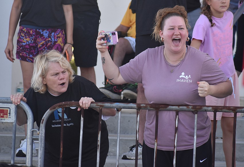 Kristi Stadler, who lives at The Haven, cheers for the bus pullers alongside Madison Gause who works at The Haven.