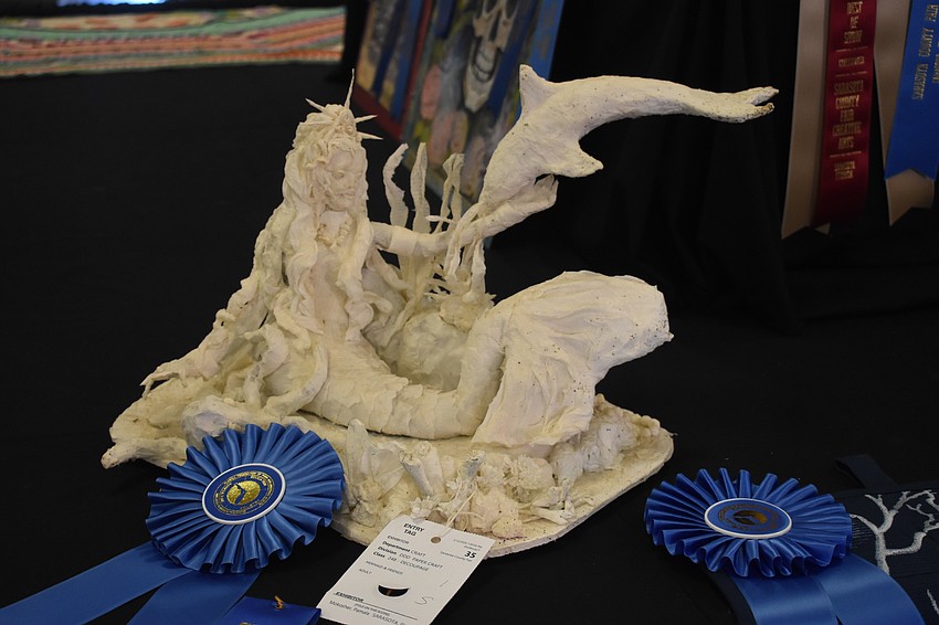 A paper craft by Pamala Mokosher is displayed in the art area.