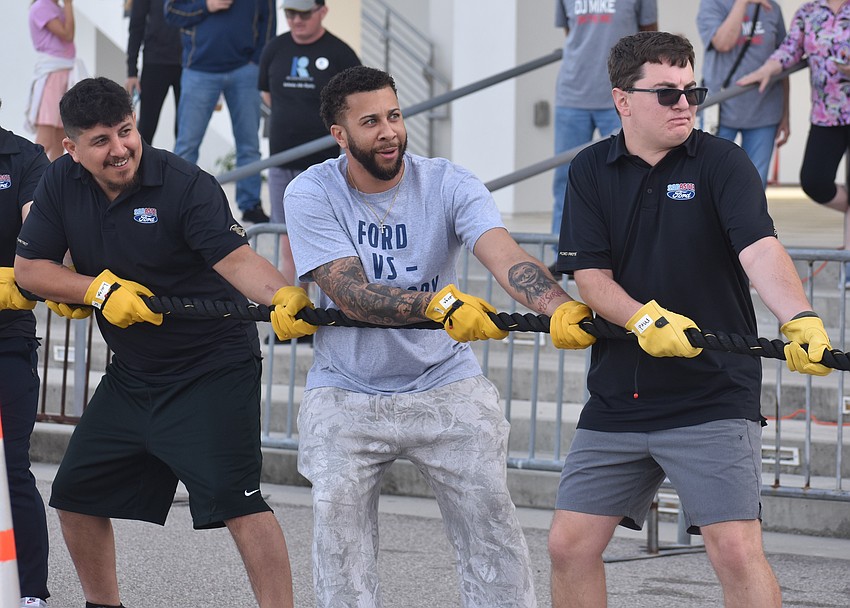 Team Sarasota Ford members Jordan Cardenas, Marvin Massenburg and Nick Lapinski pull the 20-ton Sarasota County Breeze Transit bus for the Bus Pull for Inclusion.