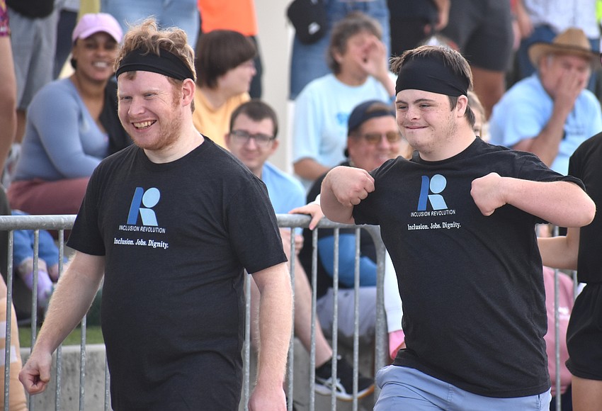 Ian Murdoch and Burk West walk away from the bus with pride after participating in the Bus Pull for Inclusion fundraiser on March 14.