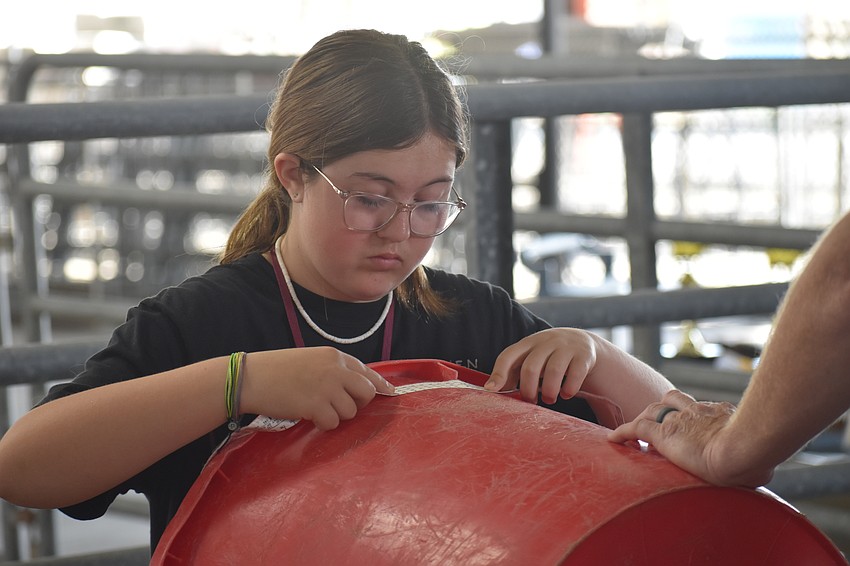 Sixth grader Grace Welden of 4-H practices measuring skills during an activity simulating different skills.
