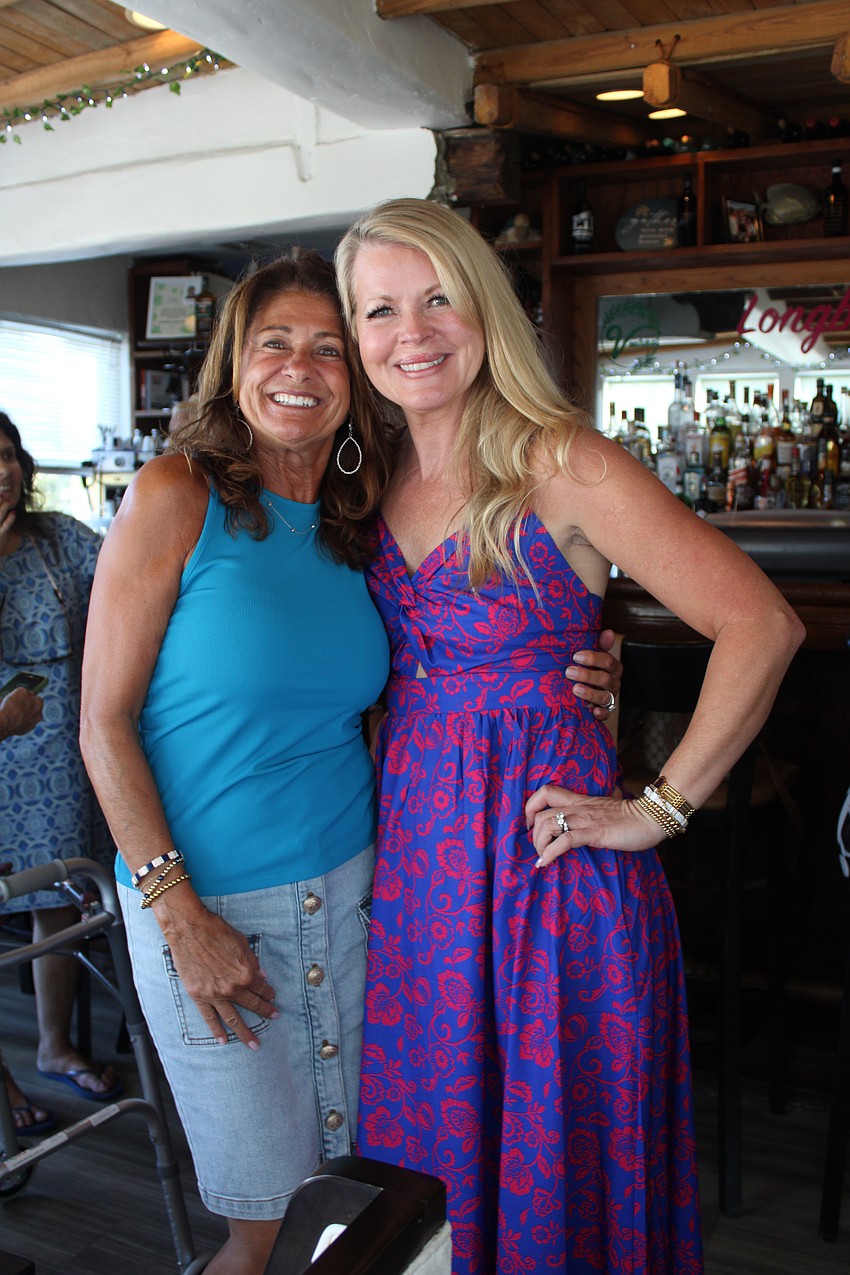 Janice Taranto and Lori Brown share a smile while sporting equally vibrant colors at the Ladies of Longboat meetup.