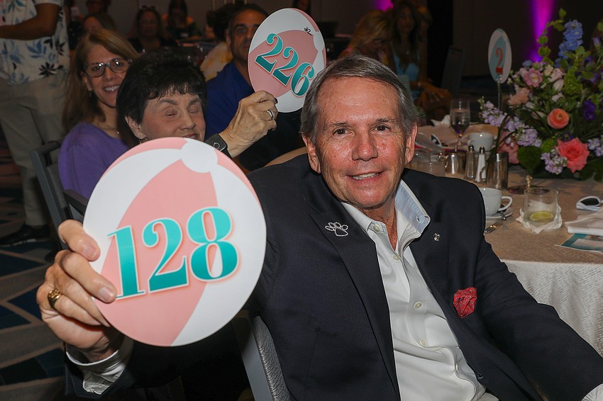 Bill Buckingham raises his paddle for the paws.