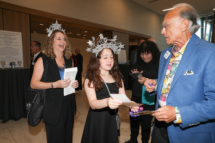 Jaime Marco's daughter, Hannah, sells raffle tickets to Michael Richker