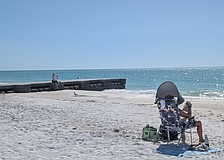 Beachgoers set up near and rest on one of two concrete permeable adjustable groins on the north end of Longboat Key.