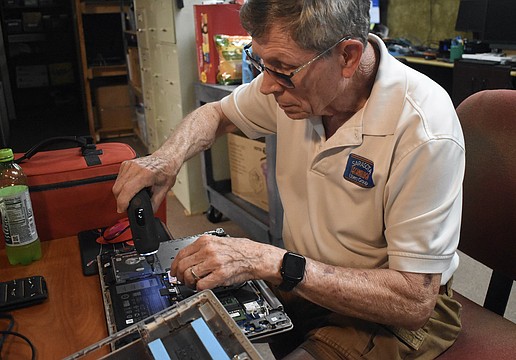 Mike Hutchinson repairs a laptop.