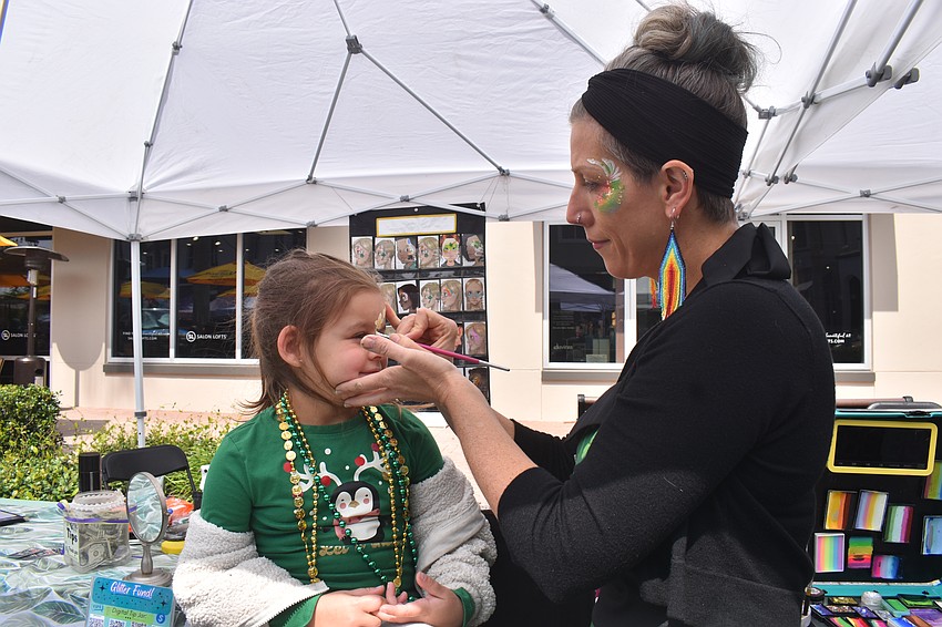 Lakewood Ranch's Callie Cecil, 6, gets her face painted by Sarasota Face Painting's Erin Ernst.