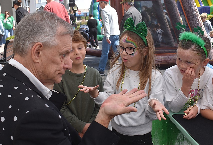 Magician Timothy Pitch does a magic trick for Lakewood Ranch's Lucas Weakley, Rosalie Miller and Kinley Badenhorst.