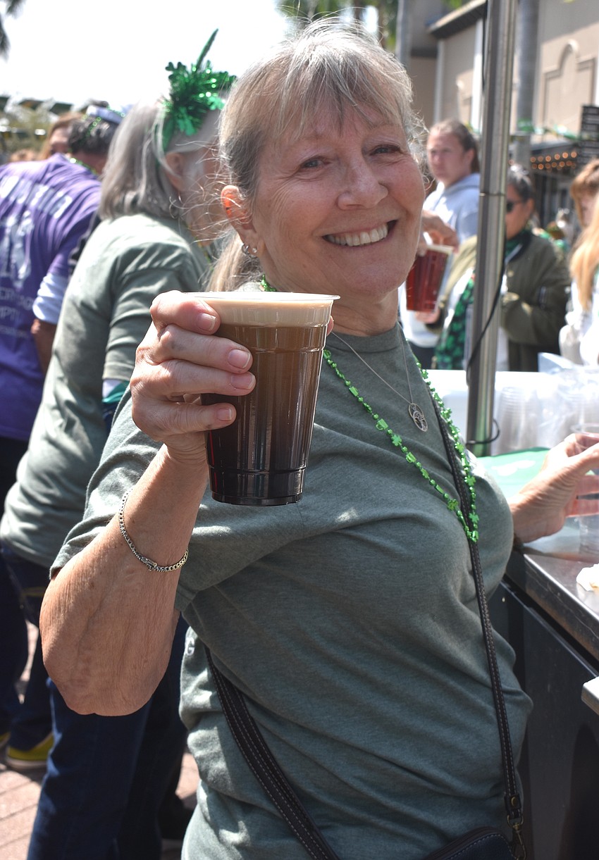 Claudia Kell is among the group of volunteers from Nate's Honor Animal Rescue Center to serve Irish beer.