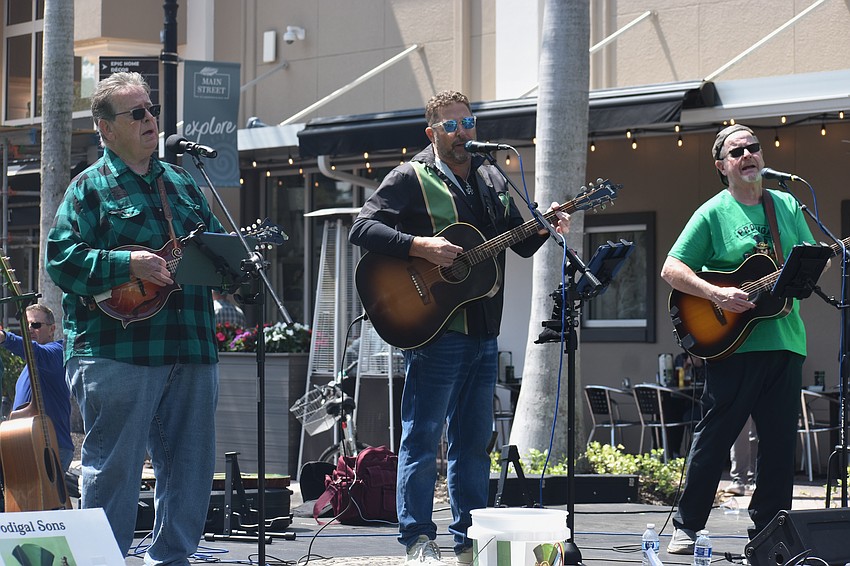 Tom McNulty, Dana Lawrence and Johnny Mac McNulty of Prodigal Sons perform Americana, folk and Irish tunes on St. Patrick's Day on Lakewood Main Street.