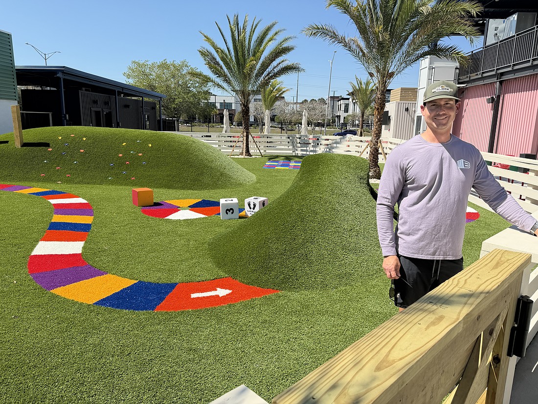 Daniel Moffatt stands in the children’s playground he designed at The Block Jax, in which kids can play on life-size Candy Land and Chutes and Ladders-themed features.