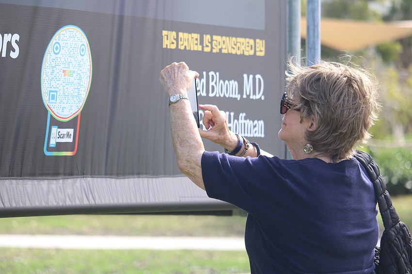 Carole Mitter utilizes the QR code feature of the art pieces on display at Embracing Our Differences. The online companion has information on the artists and more.