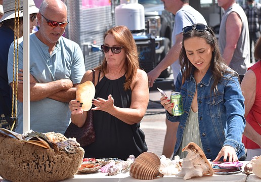 Glenn and Linda Courtney and their daughter Chelsea Courtney look at seashells.