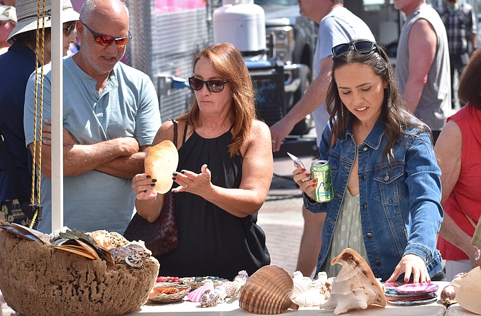 Glenn and Linda Courtney and their daughter Chelsea Courtney look at seashells.