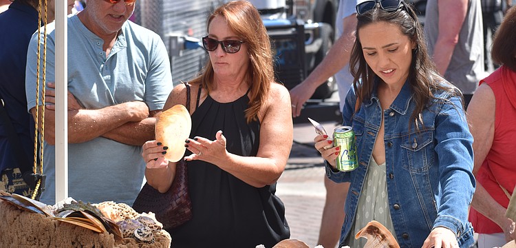 Glenn and Linda Courtney and their daughter Chelsea Courtney look at seashells.